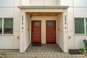 A building entrance with two red doors, numbered 5210 B and 5210 A, and a small step leading up to the entrance. - Sleek 3BR Seattle Townhome - Near UW-Husky Stadium (Seattle)