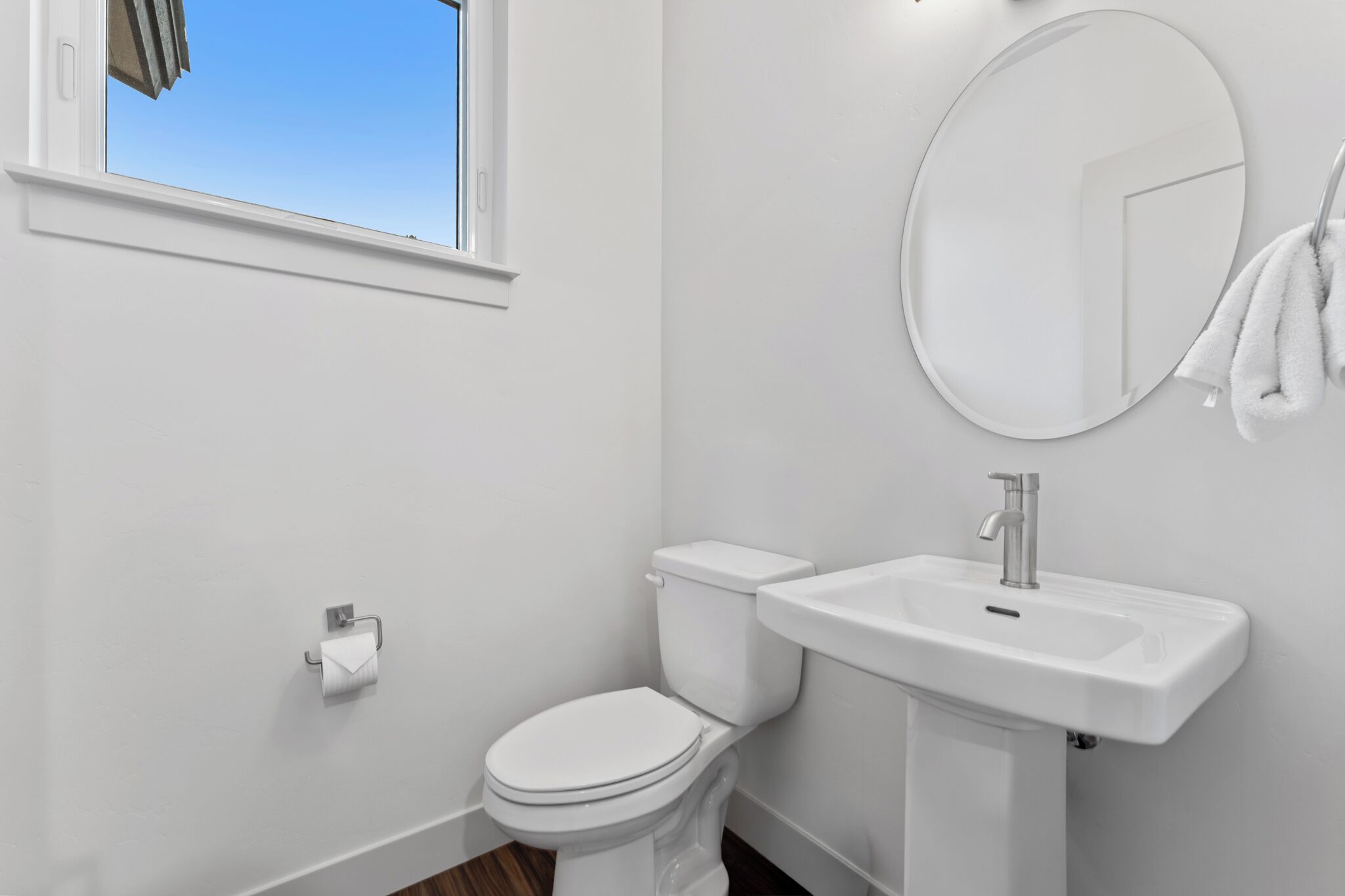 A modern bathroom with a toilet, sink, and mirror.