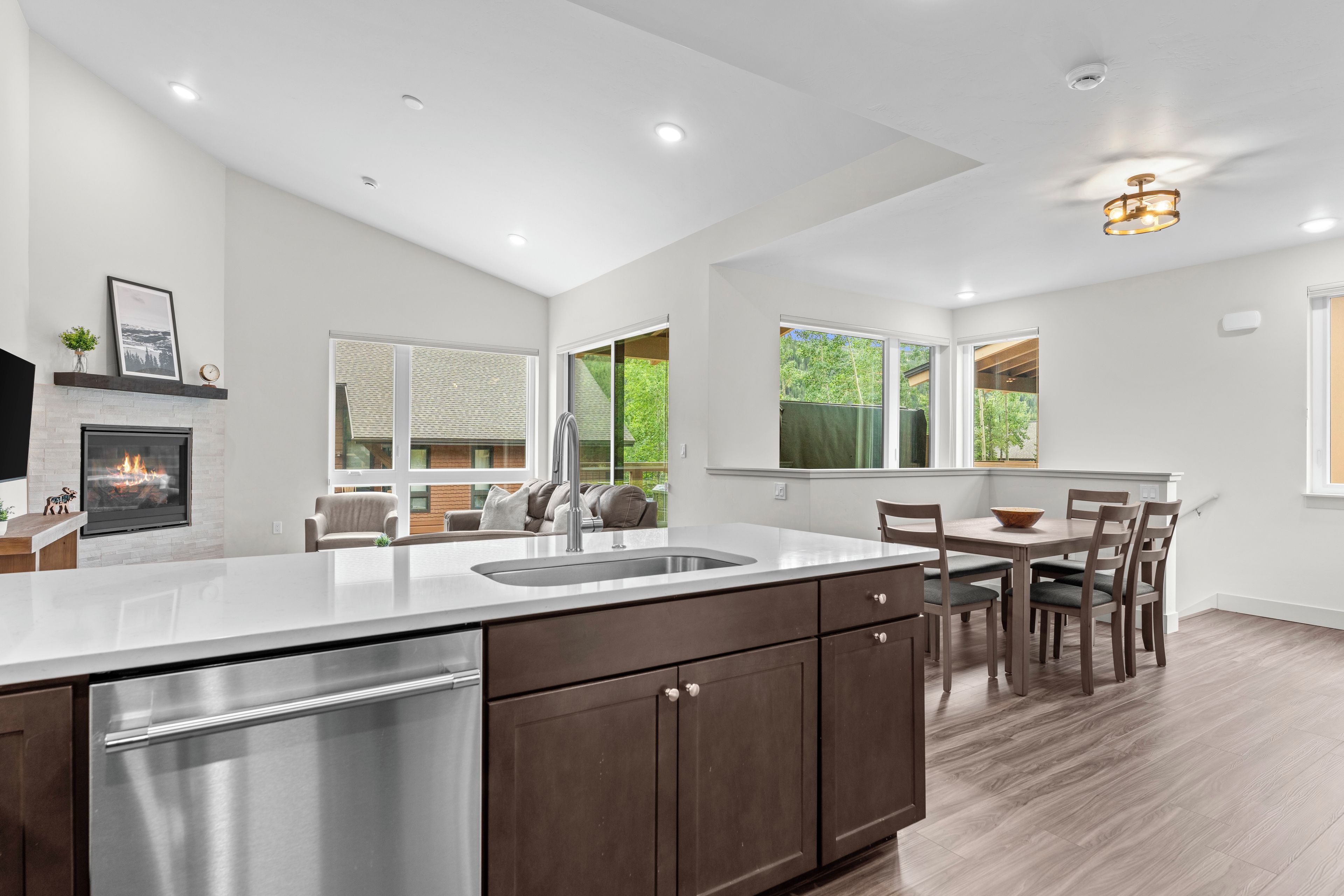 A modern kitchen with a central island, stainless steel appliances, and a fireplace.