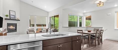 A modern kitchen with a central island, stainless steel appliances, and a fireplace.