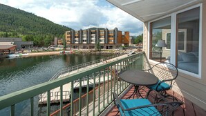 A balcony with a view of a river, a dock, and a building with multiple floors. - Ls1476-0 (Keystone)