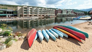 A waterfront hotel with multiple buildings, a dock with boats, and a sandy beach area. - Ls1476-0 (Keystone)