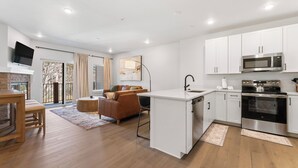 Una cocina moderna con armarios blancos, microondas integrado y estufa.