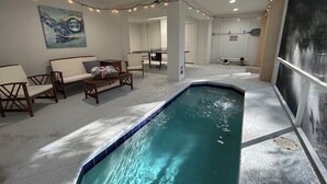 Uma área de piscina com área de estar, um quadro na parede e um aviso.