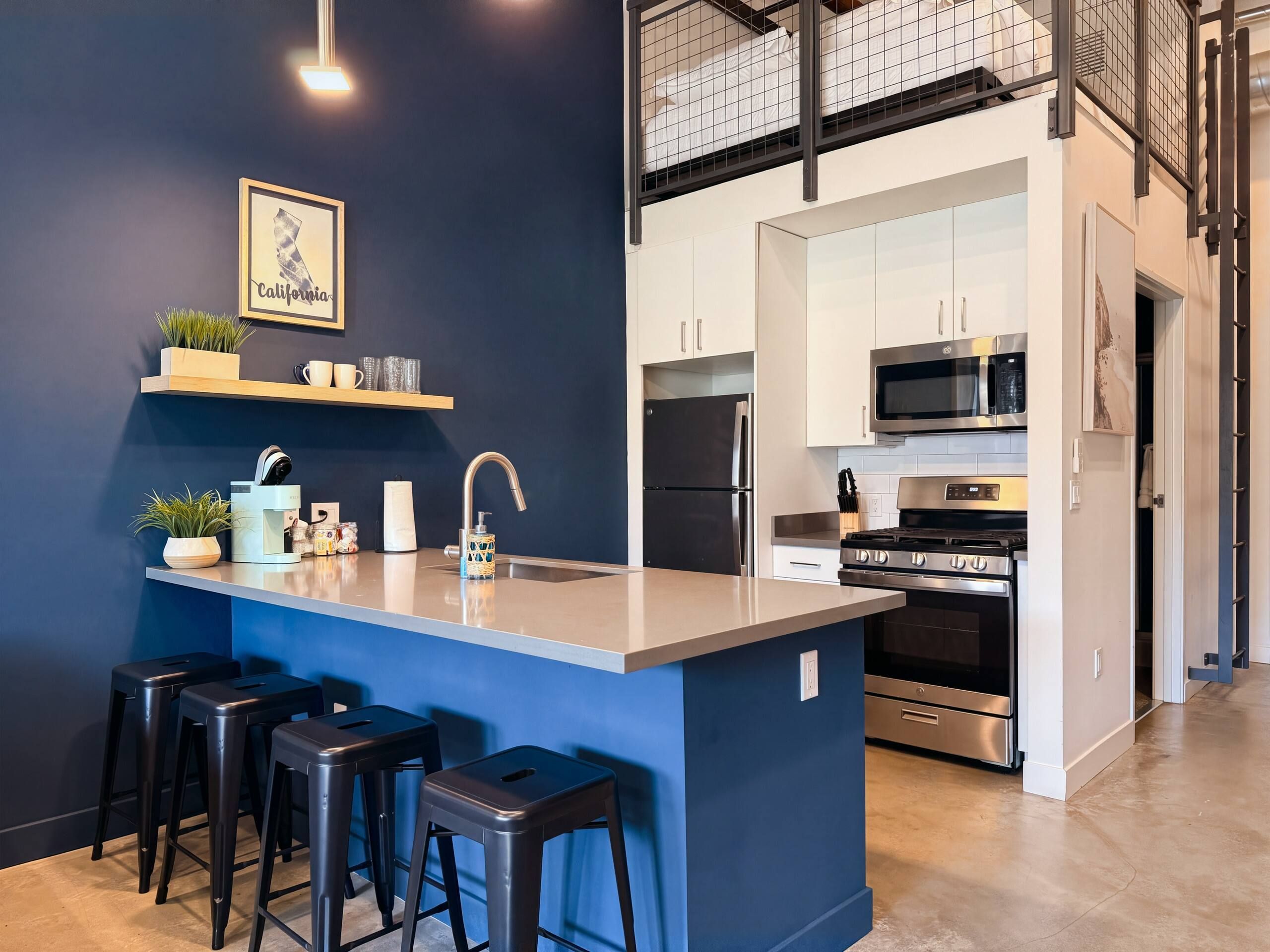 Une cuisine moderne dotée d’un îlot central, de tabourets de bar et d’un four à micro-ondes.