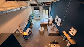 A modern interior with a kitchenette, seating area, and a large window providing a view.
