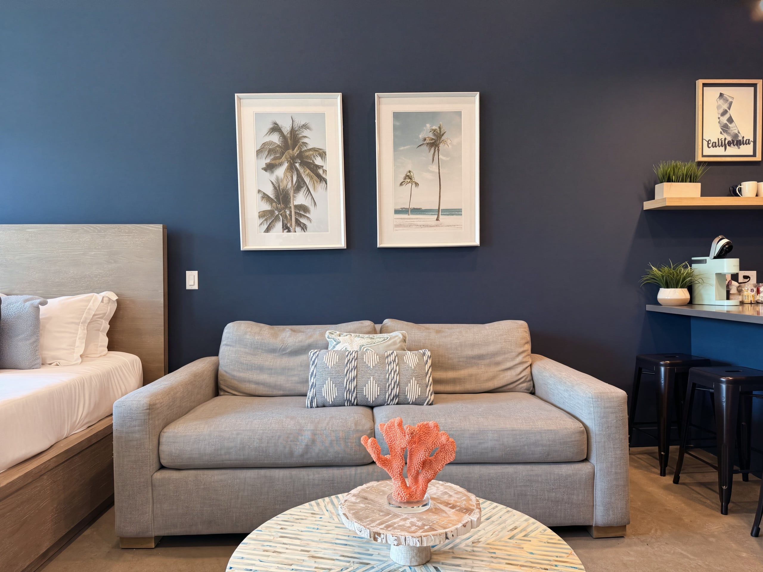 A living room with a sofa, a coffee table, and two framed pictures on the wall.