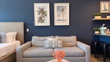A living room with a sofa, a coffee table, and two framed pictures on the wall.