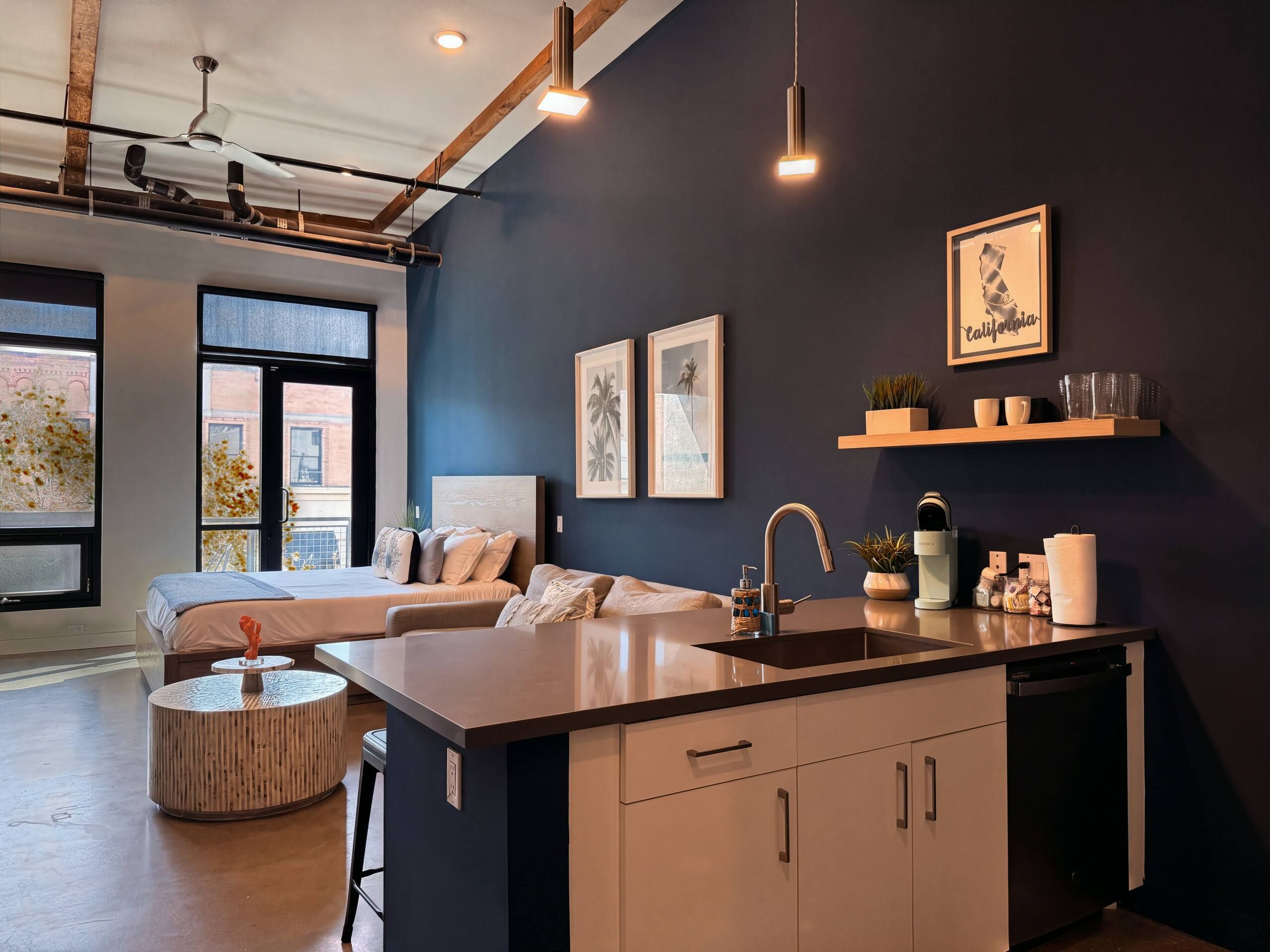 Una cucina moderna con isola centrale, lavello incassato e ventilatore a soffitto.