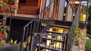 A wooden cabin with a staircase leading to a balcony.