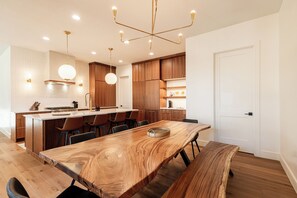 A modern kitchen with wooden cabinets, a large island, and pendant lighting. - Spacious 4BR home in Park City with mountain views, perfect for 11 guests! (Park City)