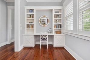 A study with a white desk, bookshelves, a chair, and a window with blinds. - Tranquil Waterfront Retreat + Sunrise Views (Bluffton)