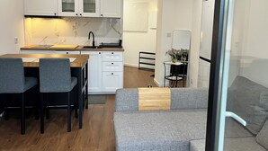 Una cocina moderna con armarios blancos, encimera de madera e instalación de lavabo integrada.