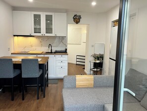 Eine moderne Küche mit weißen Schränken, einer Holz Arbeitsplatte und einer eingebauten Spüle.