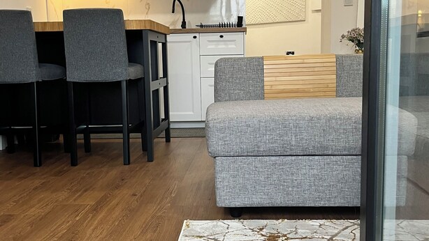 Una cocina moderna con armarios blancos, una mesa de comedor de madera y dos sillas grises.