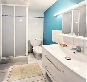 A bathroom with a shower, toilet, sink, and mirror. - L'authentique océane – A cozy getaway in Le Croisic (LE CROISIC)