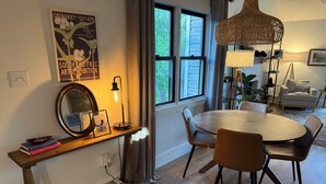 A dining area with a round table, chairs, a hanging light fixture, a mirror, and a poster on the wall. - Beautiful and Spacious 4-bedroom home in Lynchburg (Lynchburg)