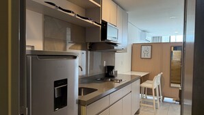 Una cocina moderna con electrodomésticos de acero inoxidable, horno empotrado y cafetera.