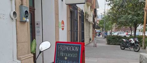 Una motocicleta estacionada frente a un edificio con un cartel anunciando una promoción.