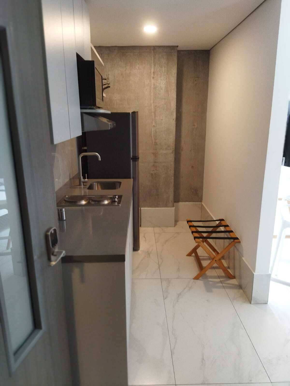 Una cocina compacta con horno integrado, lavamanos y un pequeño tendedero.