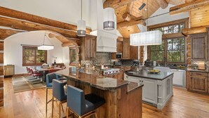 Una cocina amplia con vigas de madera, una isla grande y taburetes de bar.