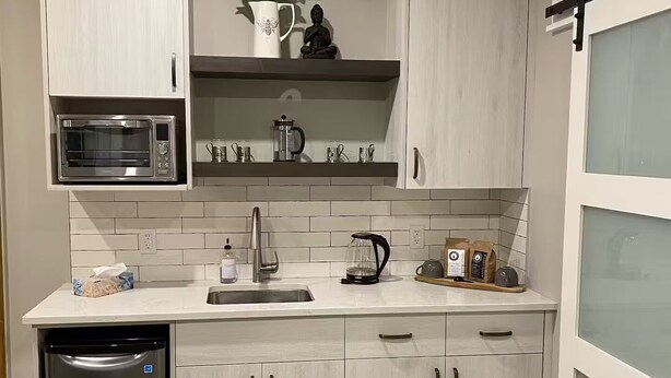 Eine moderne Küche mit eingebauter Mikrowelle, einer Kaffeemaschine und einem Geschirrspüler.