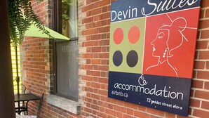 Ein Backsteinhaus mit einem Schild für die Unterkunft Devin Suites.