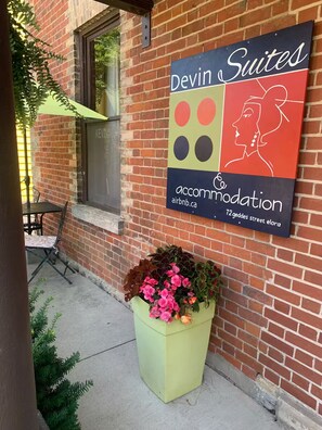 A brick building with a sign for Devin Suites accommodation.