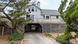 A two-story house with a covered walkway leading to a garage. - Thistle: Semi-Oceanfront home in Duck, Elevator, Sanderling Community Amenities (Duck)