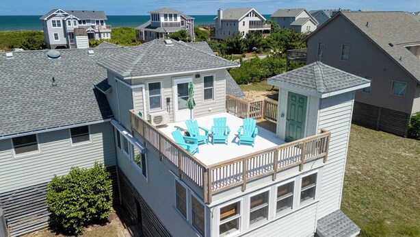 A multi-story house with a rooftop deck, a small shed, and a view of the ocean. - Thistle: Semi-Oceanfront home in Duck, Elevator, Sanderling Community Amenities (Duck)