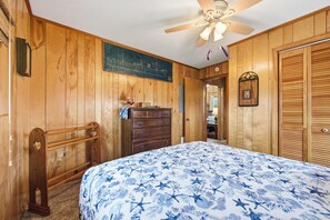 A wooden-paneled room with a bed, dresser, and a ceiling fan. - Thistle: Semi-Oceanfront home in Duck, Elevator, Sanderling Community Amenities (Duck)