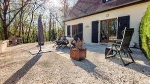 Una casa con patio, area relax all'aperto e barbecue.