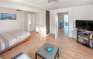 A bedroom with a bed, a desk, a TV, and a bookshelf. - 1 bedroom nice apartment in Pleubian (Pleubian)