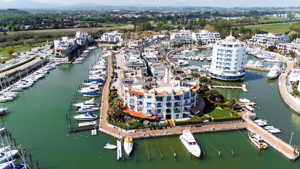 A marina with multiple boats docked, surrounded by residential buildings with balconies.