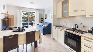 A modern kitchen with a gas stove, oven, and a dining area with a table and chairs.