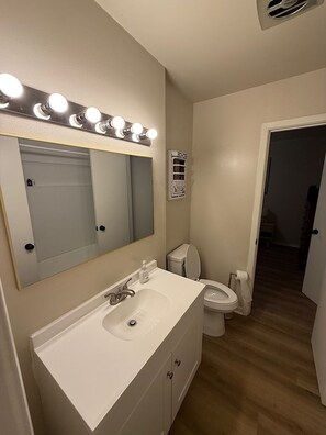 Ein Badezimmer mit Waschbecken, Spiegel, Toilette und Waschtisch.