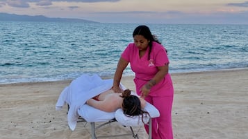 On the beach, white sand, beach towels, beach massages