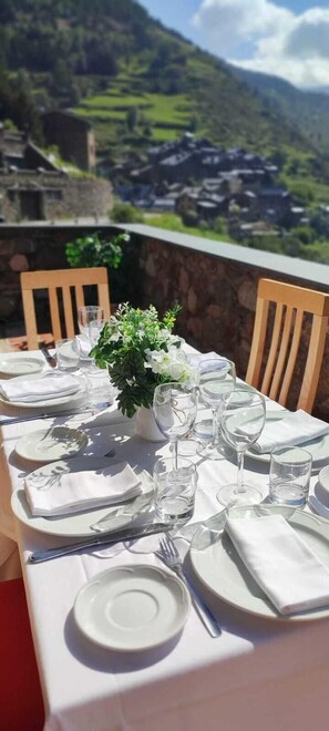 A table set for dining with a mountain view in the background. - Ransol (Ransol)