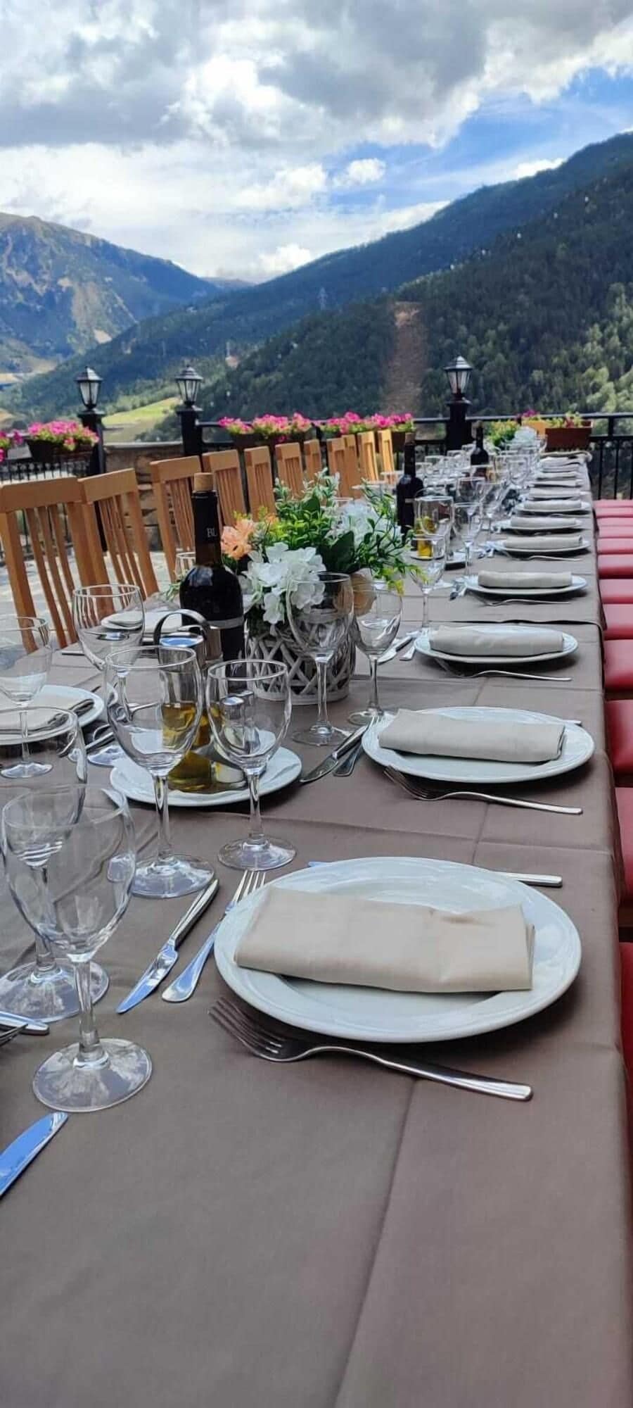 Une table dressée pour le dîner, avec une vue sur les montagnes en arrière-plan.