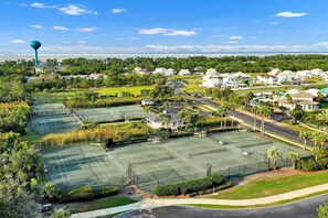 Zona residencial con varias canchas de tenis, casas y un tanque elevado de agua.