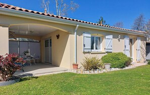 Una casa de un piso con un porche cubierto, una puerta y ventanas con contraventanas.