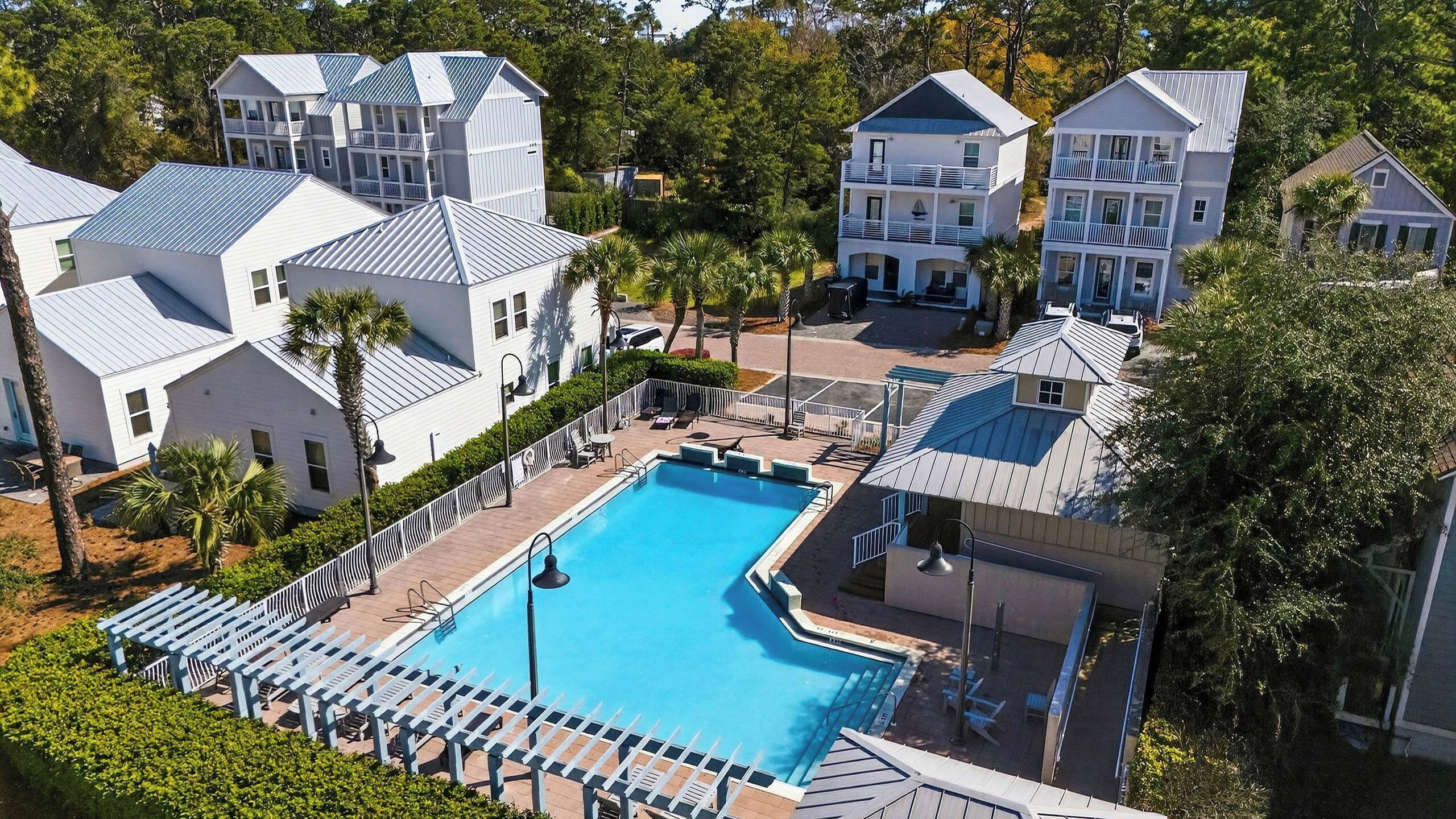 A resort with a central swimming pool, multiple-story buildings, and a well-maintained landscape.