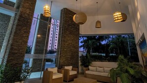 A modern interior with wicker furniture, large windows, and hanging pendant lights. - Ocean View and Direct Beach in Pozos Colorados (Santa Marta)