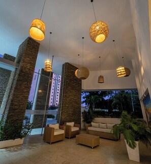 A modern interior with wicker furniture, large windows, and hanging pendant lights. - Ocean View and Direct Beach in Pozos Colorados (Santa Marta)