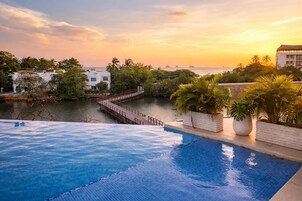 Una piscina con vista al mar y palmeras.