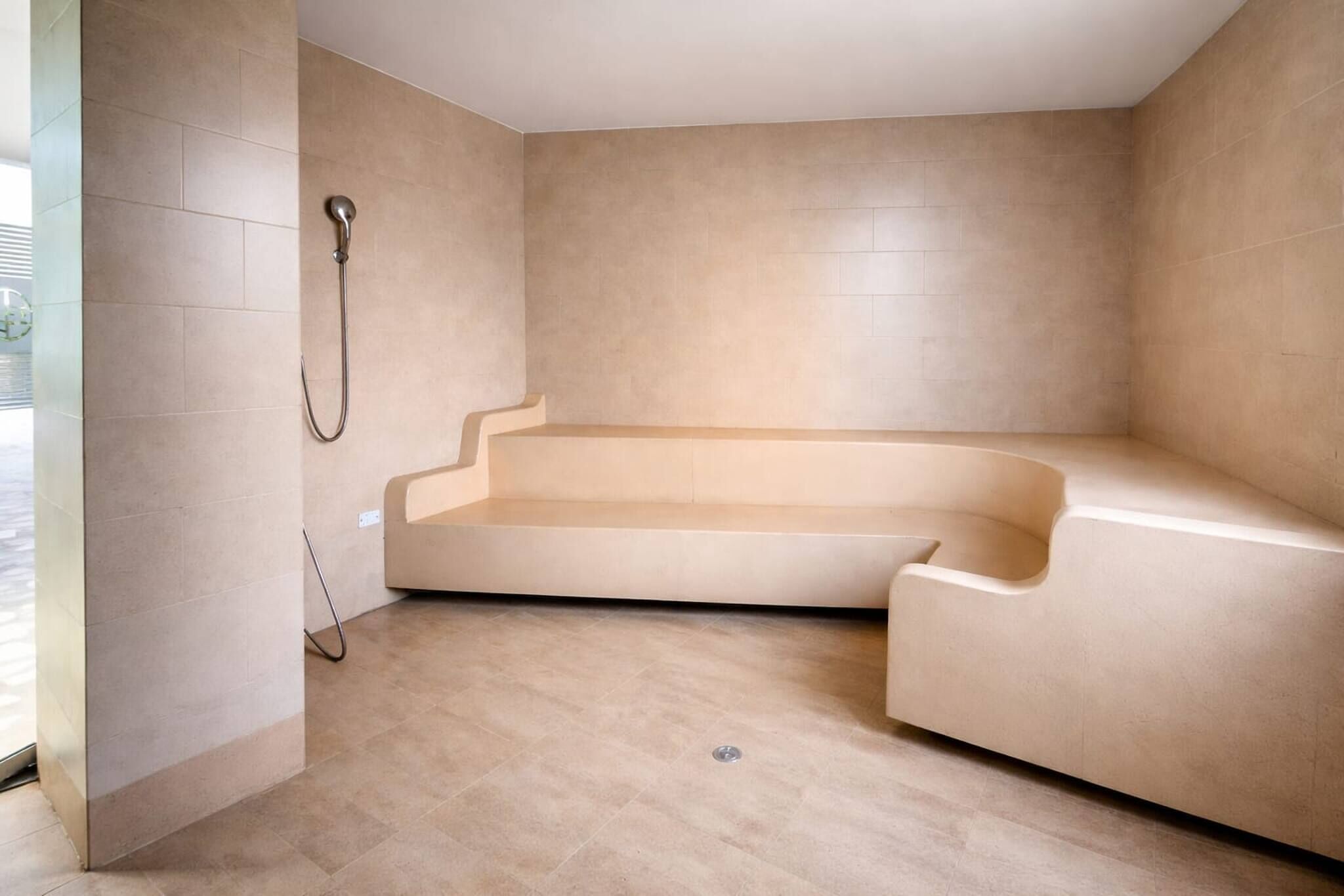 A modern bathroom with a freestanding bathtub, a showerhead, and a tiled floor.