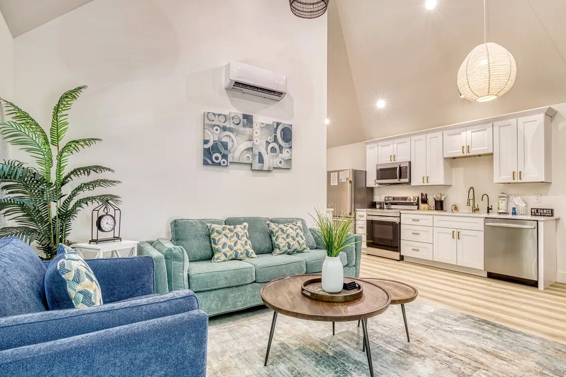A modern living room with a sofa, coffee table, and decorative plants.