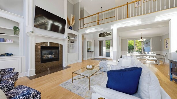 A spacious living room with a fireplace, high ceilings, and a dining area with natural light. - Belle Pines Hideaway by Avantstay Lakefront + Hot Tub + Fire Pit + Game Room Near Charlotte (Sherrills Ford)