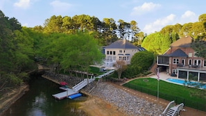 A large house with a dock, a swimming pool, and a well-maintained lawn. - Belle Pines Hideaway by Avantstay Lakefront + Hot Tub + Fire Pit + Game Room Near Charlotte (Sherrills Ford)