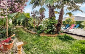 A garden with a wooden deck, palm trees, and potted plants. - Stunning home in Saint-Laurent-d'Aigouz (Saint-Laurent-d'Aigouz)